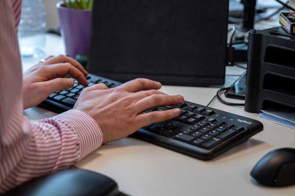 Hands typing on computer keyboard