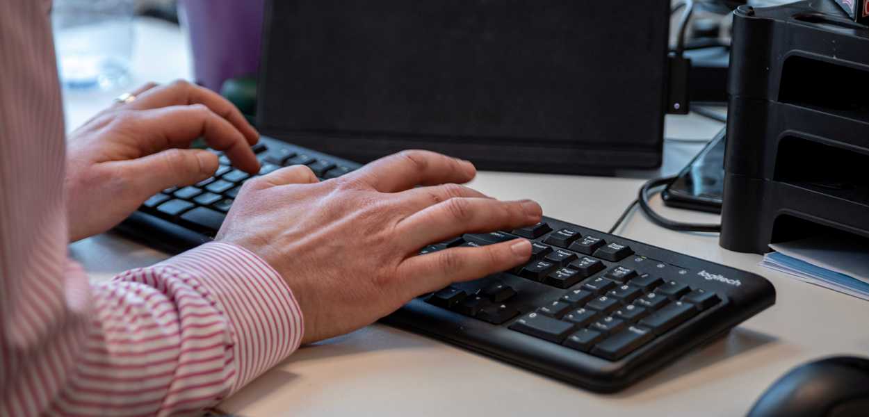 Hands typing on computer keyboard