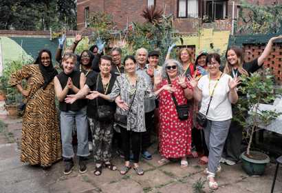 Group of people smile and hold their hands in the air