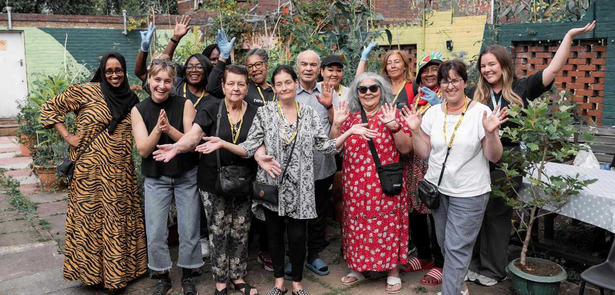 Group of people smile and hold their hands in the air