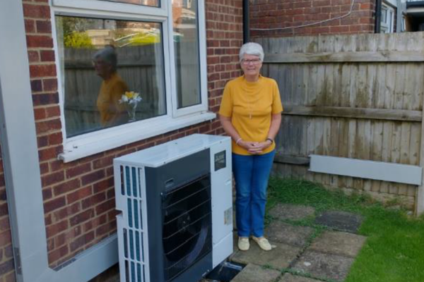 Resident smiles with air source heat pump 
