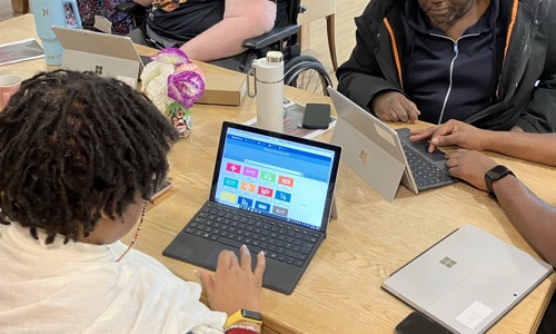 A man holds and ipad and a woman points at it