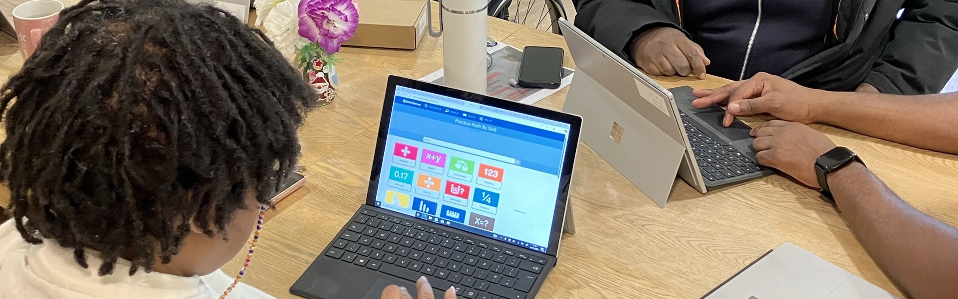 A man holds and ipad and a woman points at it