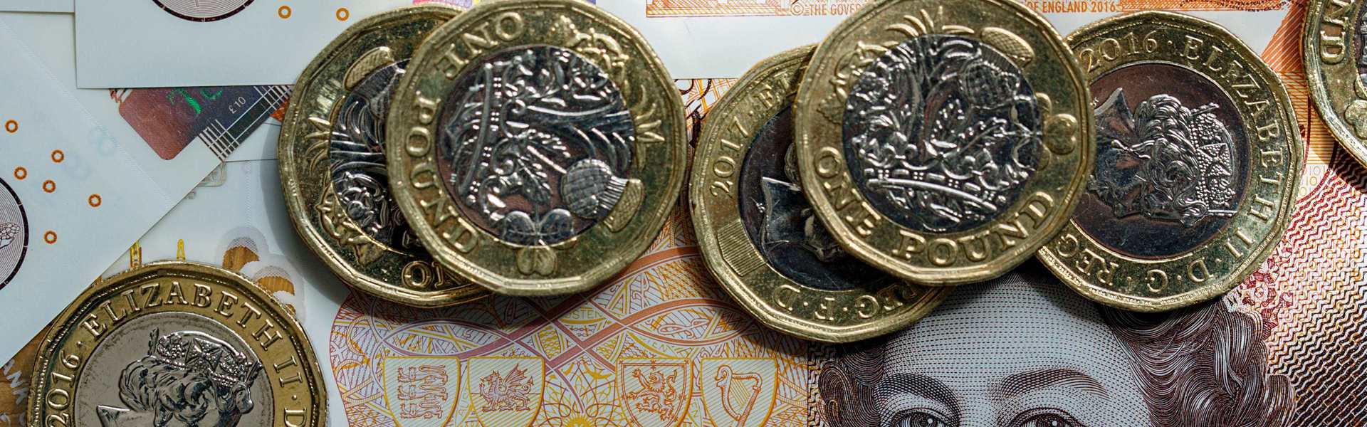 Pound coins sitting on a £10 note