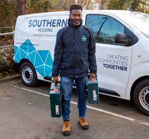 image: a member of the Southern Housing repairs team collecting their tools from their van